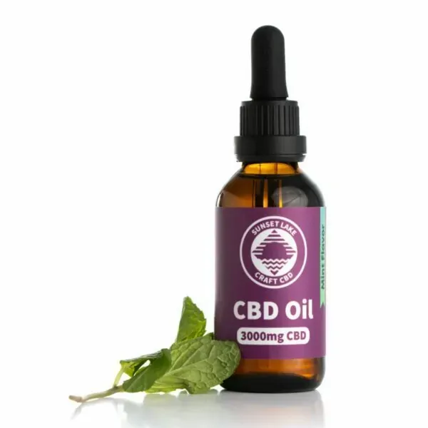 Mint-flavored 3000mg CBD oil next to a sprig of mint