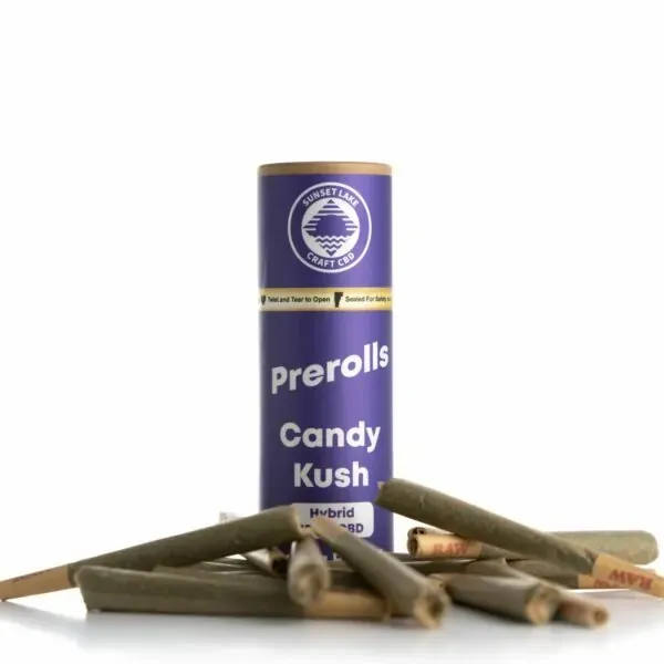 A tube of Candy Kush prerolls surrounded by pre-rolled joints