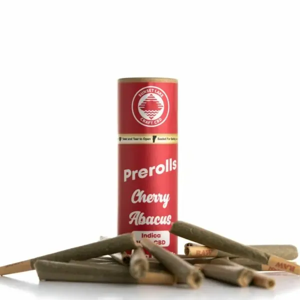 A tube of Cherry Abacus Prerolls surrounded by pre-rolled joints